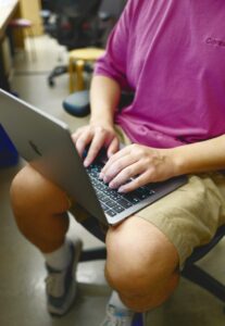 student typing on computer